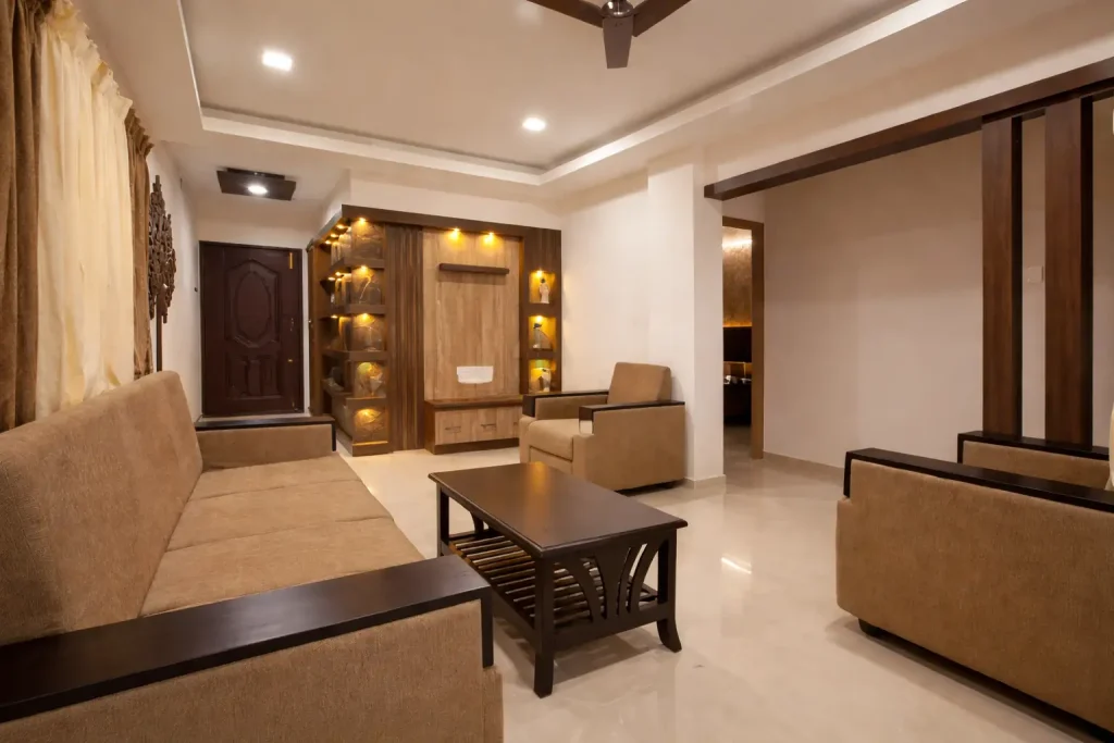 Contemporary Indian living room design with wooden showcase unit, beige sofa set, warm lighting, and modern false ceiling