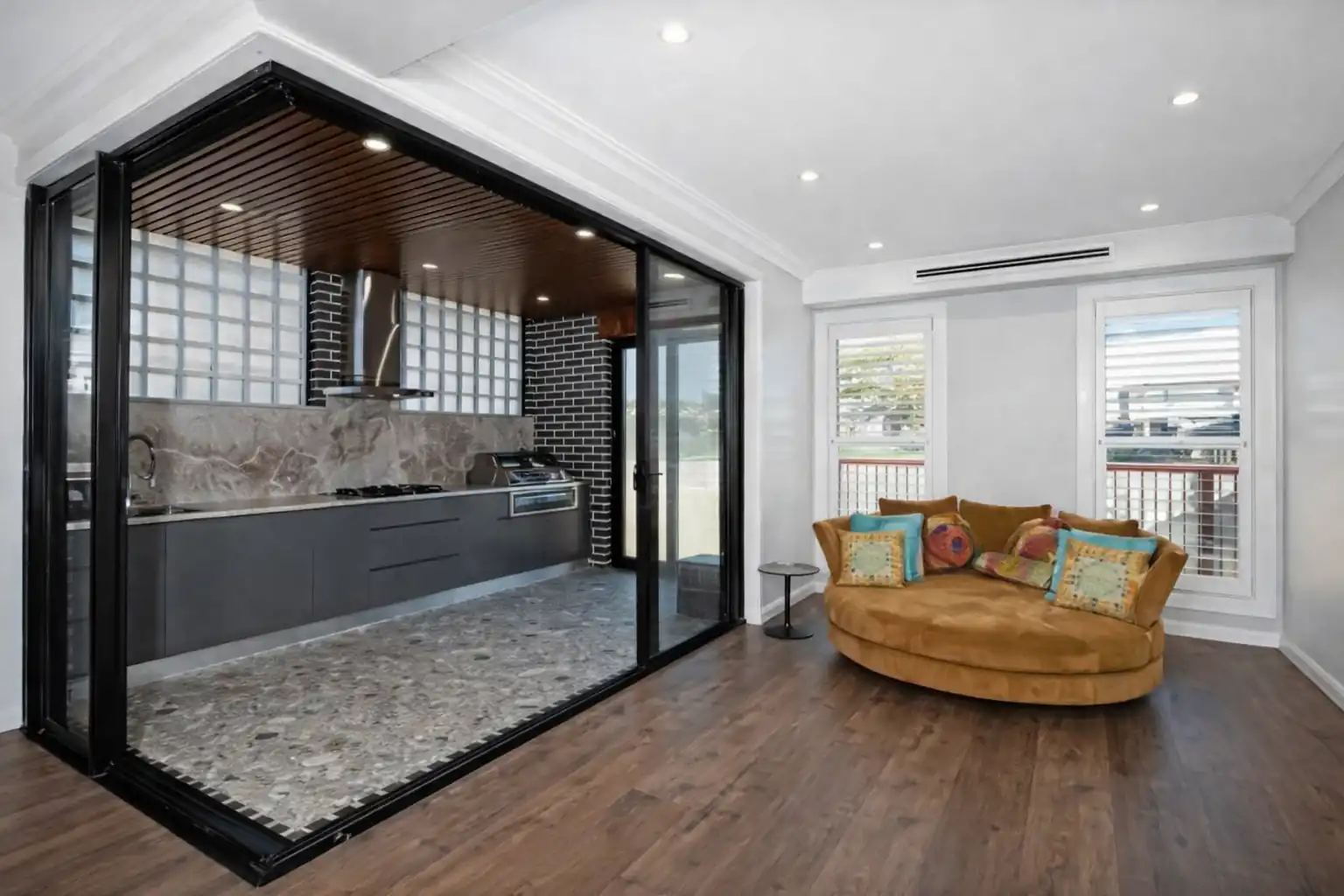 modern kitchen with glass partition, sliding doors, open living space, and cozy seating area