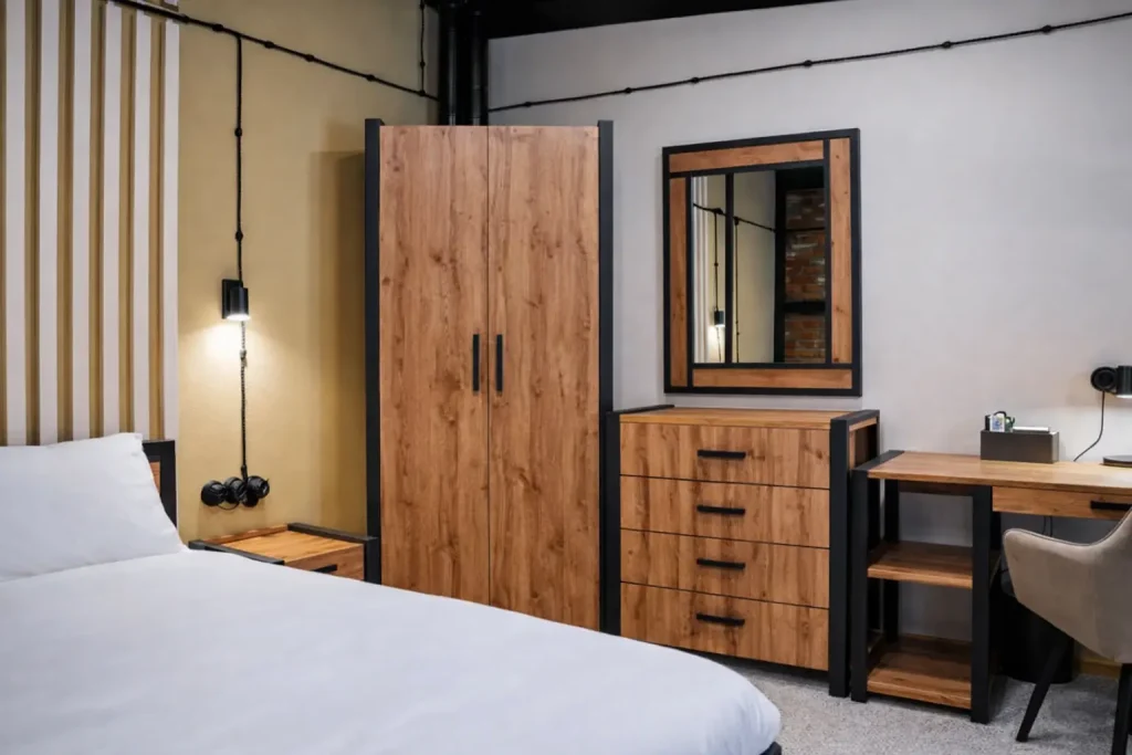 Cozy neutral bedroom with white bed, decorative pillows, and flowers on wooden table