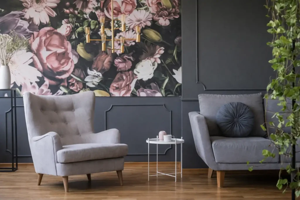 Elegant modern living room with dark floral wall mural, grey armchairs, wooden flooring, and decorative lighting