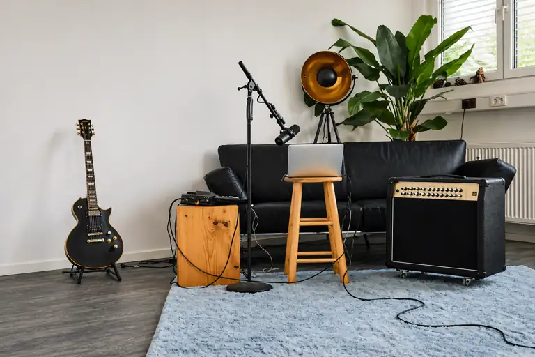 cozy music corner with acoustic guitar, bass guitar, chair and warm interior decor