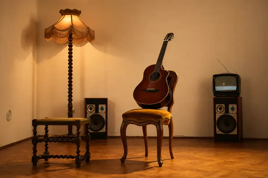vintage style room with acoustic guitar on chair, retro lamp and speaker